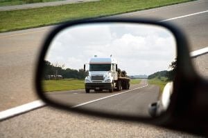 sideview mirror showing commercial truck