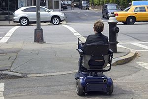 person in electric wheelchair crossing an intersection