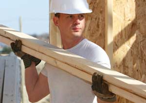 construction worker holding piece of wood