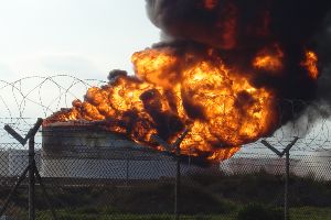 explosion at oil refinery behind fence