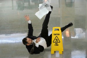 man in a suit slipping on wet floor