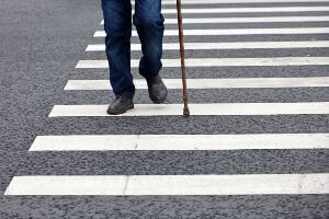 man with cane in crosswalk