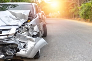 vehicle with front-end crash damage at sunset